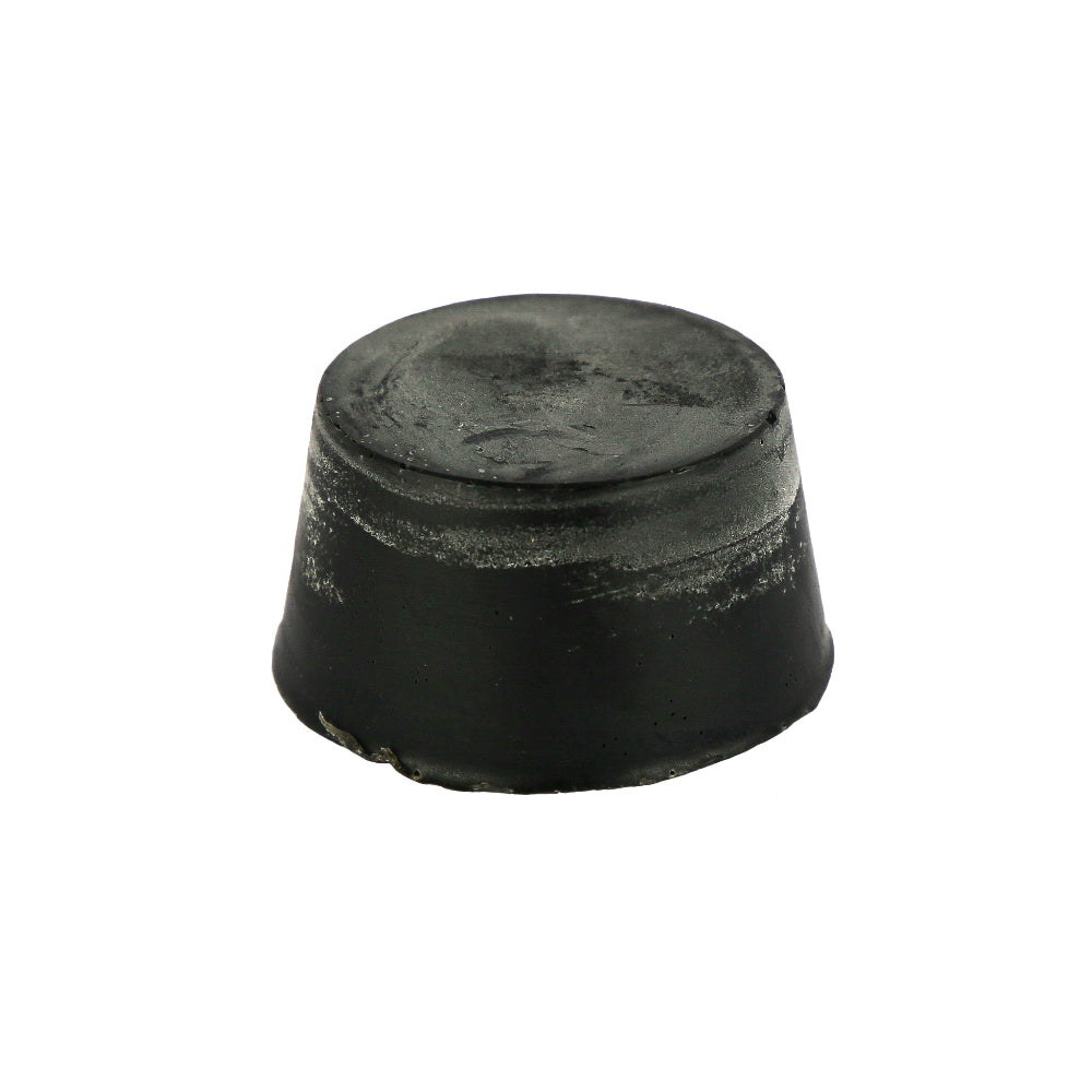 A black round block of Aniseed, Blood Orange and Activated Charcoal soap with a textured surface.