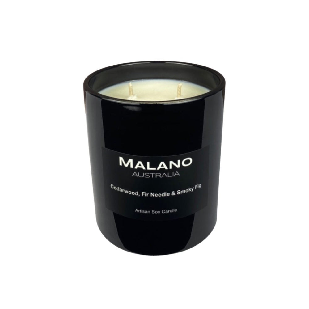 A black soy wax candle with two wicks, labeled 'MALANO', with a fragrance description of 'Cedarwood, Fir Needle & Smoky Fig' in a black glass jar with a weight of 390 grams sitting against a black background