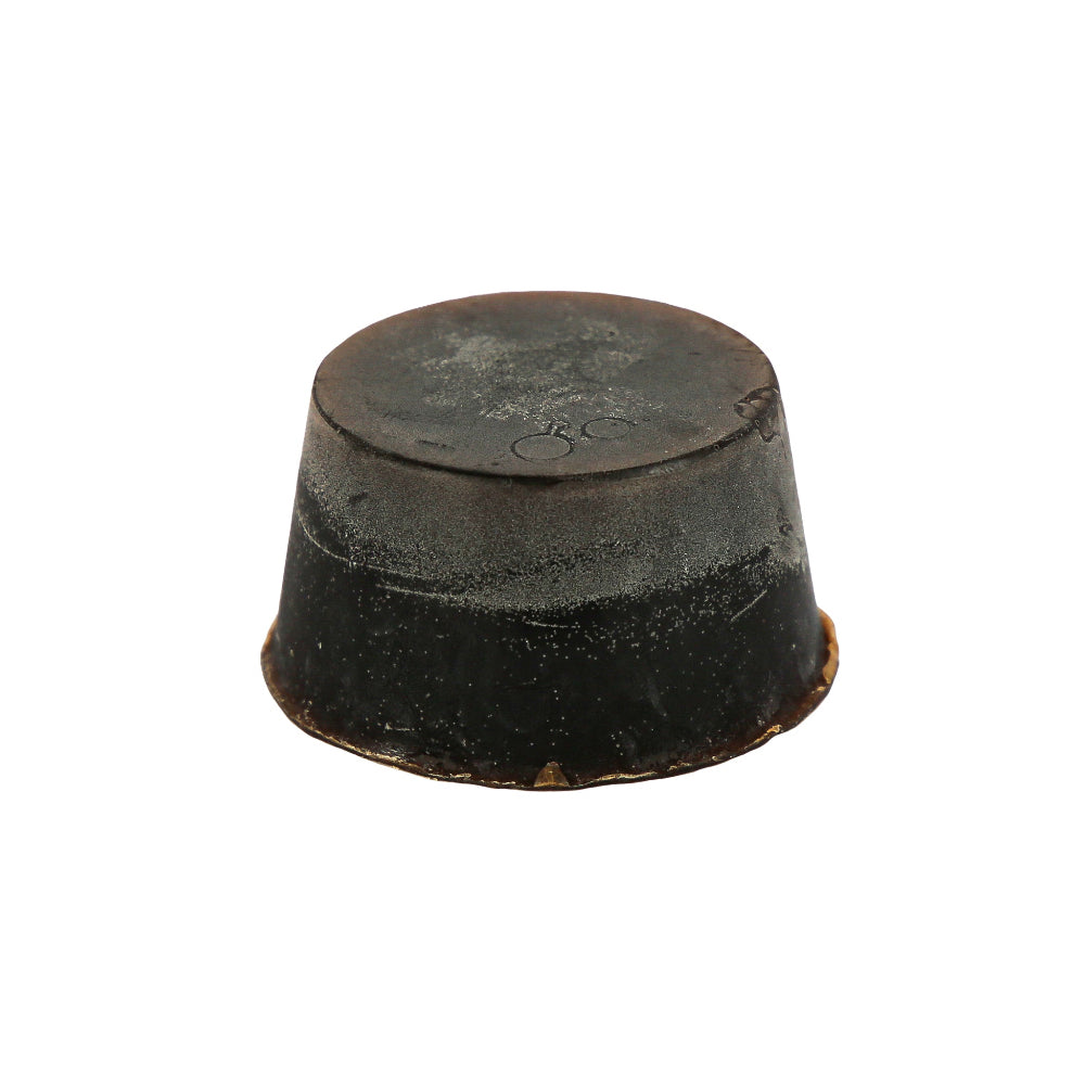 A round block of soap, dark brown in colour with the scent of Guinness, Huon Pine and Scotch Pine. This soap block is sitting against a white background.