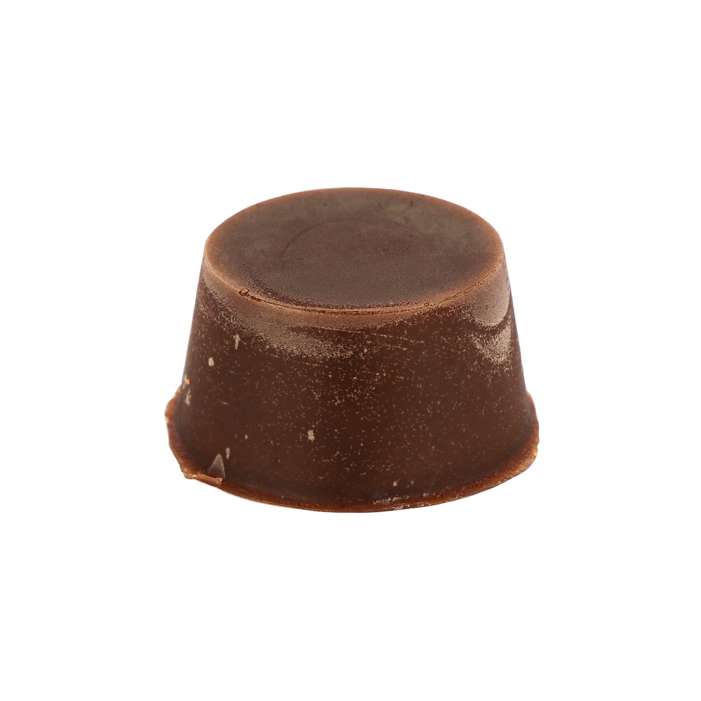 A brown solid round organic multifunction soap black made by Malano sits agains a white background.