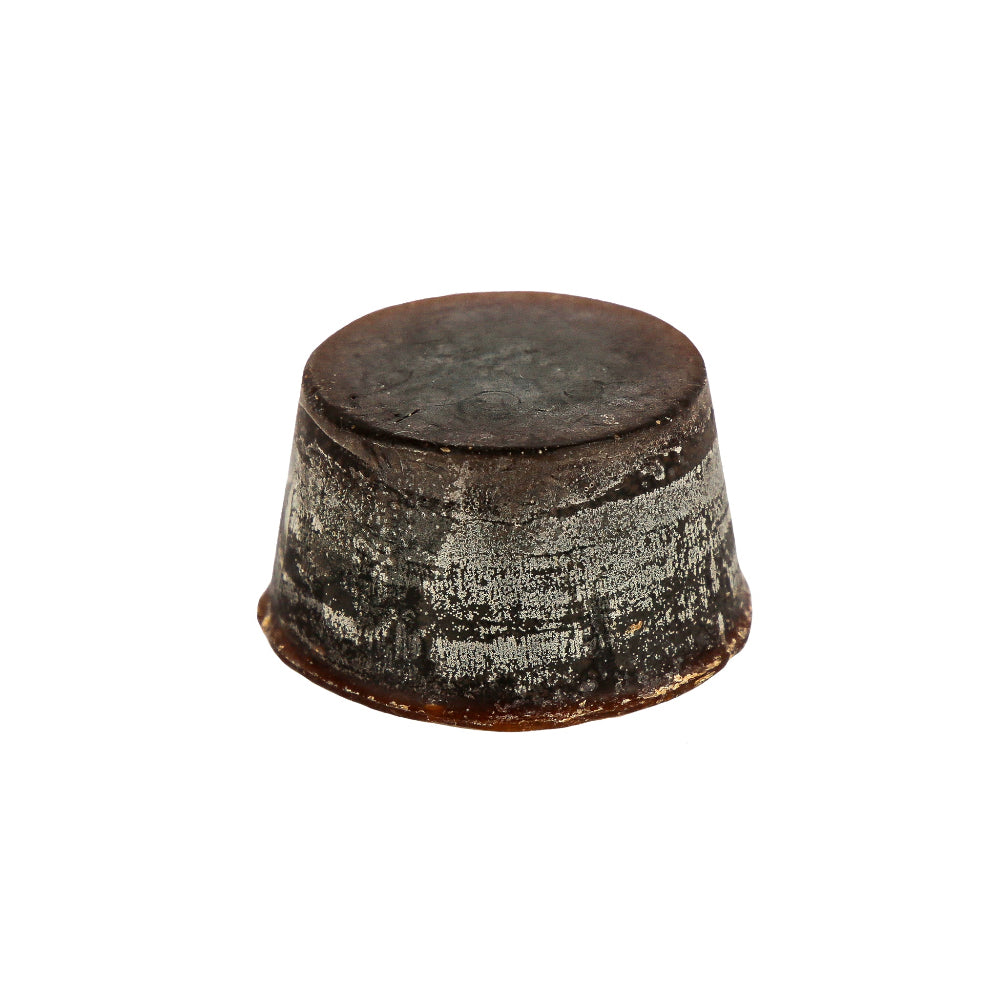 A solid block of dark brown coloured Orchid, Musk and Sandalwood scented soap with a textured surface.