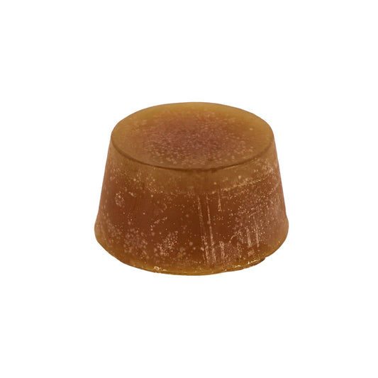 A round block of Blood Orange, Basil and Lime, scented soap, with a dark orange colour and a textured surface.