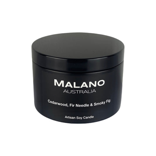 Black matte tin soy candle by Malano with lid, featuring a warm and earthy scent of cedarwood, fir needle, and smoky fig. Hand-poured artisan candle for luxury home fragrance and relaxation. Sitting agianst a black background