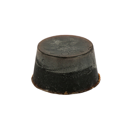 A round block of soap, dark brown in colour with the scent of Guinness, Huon Pine and Scotch Pine. This soap block is sitting against a white background.