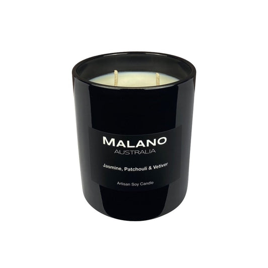 A creamy white handpoured Australian artisan soy wax candle with two wicks, branded 'Malano', with a scent of Jasmine, Patchouli & Vetiver in a large glossy black glass jar sitting against a white background.