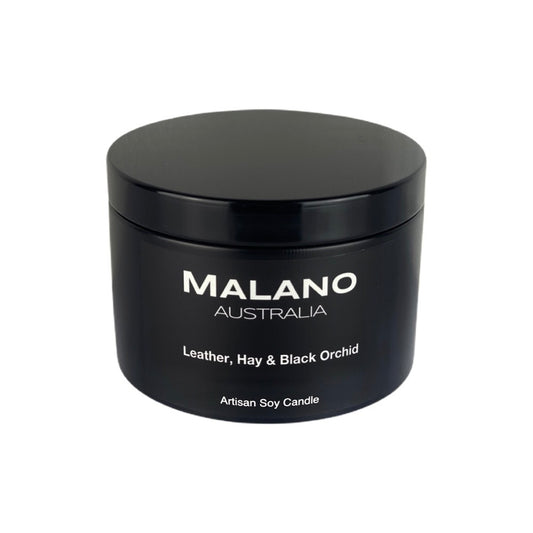 Matte Black tin containing a luxury Australian artisan, hand poured, scented soy wax candle by Malano with a woody, oriental, floral scent of Leather, Hay and Black Orchid, sitting against a white background.