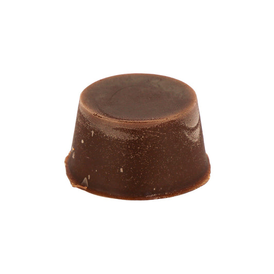 A brown solid round organic multifunction soap black made by Malano sits agains a white background. 
