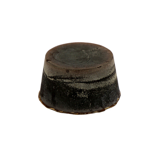 A round block of Pineapple, Coconut and Vanilla scented soap, with a dark brown colour and a textured surface.