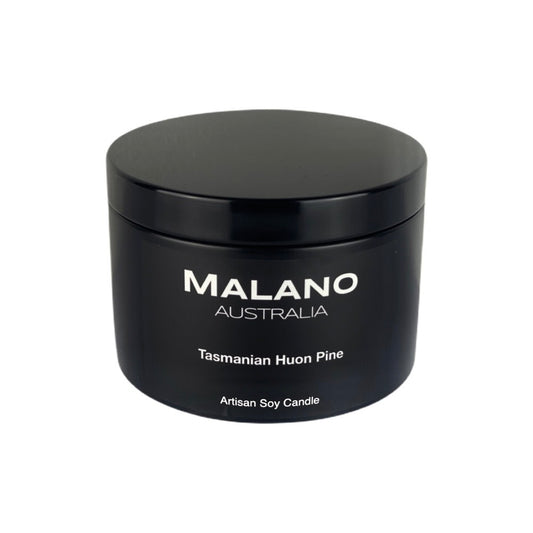 A 130g, matte black circular tin containing a luxury Australian artisan  hand poured  scented soy wax candle by Malano with a woody, fougère scent of Tasmanian Huon Pine,  sitting against a white background